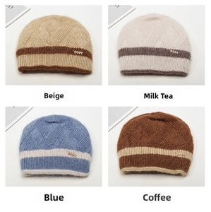 Détail de quatre bonnets en tricot colorés avec texture pelucheuse et breloque dorée
