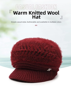 Close-up of a burgundy knit peak cap featuring plush faux rabbit fur and metal pendant detail