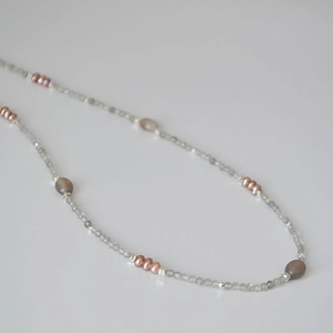 Macro detail of fine labradorite faceted beads and freshwater pearls on a minimalist necklace