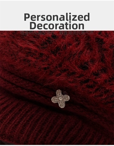 Close-up of wine red knitted hat showing fuzzy faux rabbit fur and rhinestone clover detail