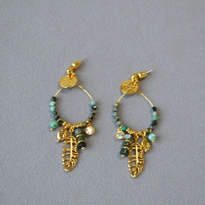 Detail view of gold dreamcatcher earrings with turquoise beads and metallic leaf pendants
