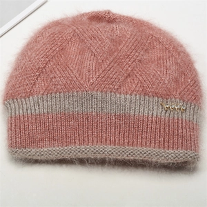 Détail macro du bonnet en tricot rose et gris avec texture mohair et décor en métal doré