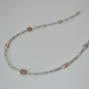 Minimalist grey labradorite and freshwater pearl beaded necklace on a neutral background