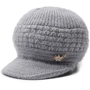Dettaglio del cappello in maglia grigio da donna con decorazione floreale in strass dorati