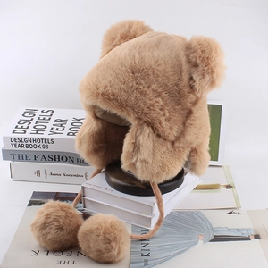 Close-up of plush bear ear hat with soft fur balls and warm winter ear flaps