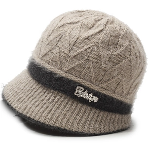 Detail of winter knit bucket hat showing cable texture and rhinestone metal logo
