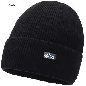 Close-up of black ribbed knit beanie featuring a mountain logo brand patch on the cuff