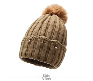 Detailed knit texture and pearl accents on a khaki pom-pom beanie for women