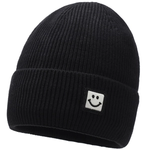 Close-up of thick ribbed knit texture and white square smiley face patch on black beanie