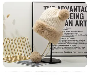 Dettaglio del berretto in maglia spessa con paraorecchie, pompon in peluche e vista laterale