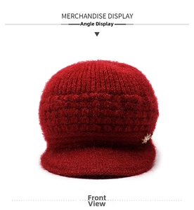 Dettaglio cappello invernale in maglia rossa con fodera spessa e farfalla metallica