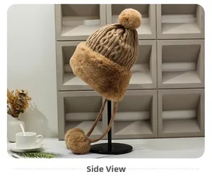 Side view of a camel knitted winter hat with faux fur trim and soft pom-poms details