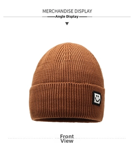 Detailed front view of the camel ribbed knit beanie featuring a stitched smiley face patch