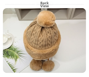 Detail view of camel knit winter hat with large faux fur pompom and plush ear flaps back