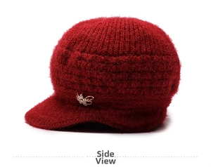 Vista laterale del cappello in maglia rosso scuro per donne con fiocco dorato