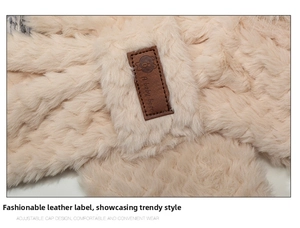 Detailed macro view of the fluffy beige faux fur material with a brown leather bear patch