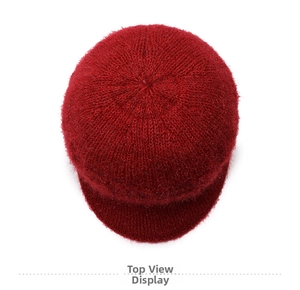 Vista dall'alto di un cappello invernale rosso scuro in maglia con trama di lana e tesa