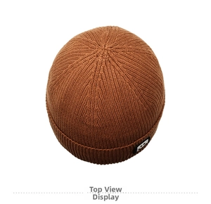 Top view of a brown ribbed knit beanie showing textured yarn and woven smiley patch