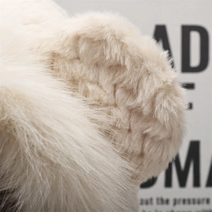 Close-up of thick beige faux fur texture on a warm winter plush hooded scarf and hat