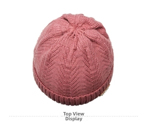 Top view of pink knit beanie showing thick vertical texture and gold metal accent