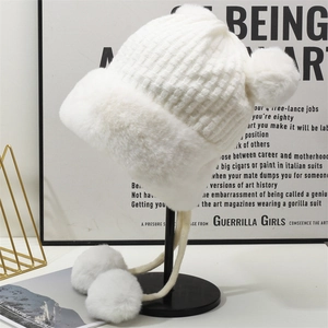 Cappello in maglia bianca spessa con paraorecchie, pompon e fodera in ecopelliccia