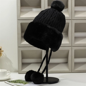 Thick black knitted winter hat with faux fur trim and cute earflap pom-poms for women