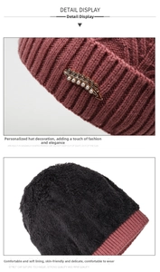 Detailed close-up of wine red knitted winter hat with thick fleece lining and pearl buckle
