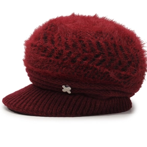 Close-up of warm faux rabbit fur texture and silver X-shaped buckle on dark red winter hat