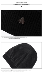 Detail view of black knit beanie with metal emblem and thick warm fleece lining