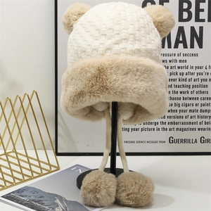 Dettaglio cappello a maglia bianca con orecchie in ecopelliccia e pompon soffici