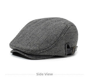 Close-up of herringbone newsboy cap featuring a side adjustable leather strap and metal buckle