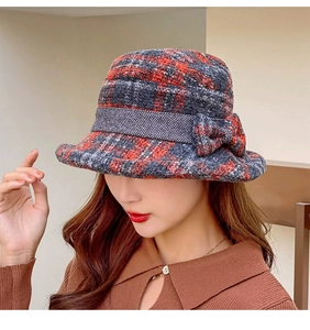 Detail of red and blue plaid tweed cloche hat with a bow, perfect for winter fashion