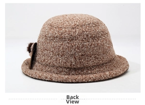Detail view of the plush teddy fleece texture and brown fur pompom on this winter bucket hat