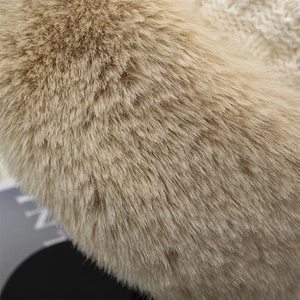 Dettaglio ravvicinato di morbido peluche beige e maglia grossa bianca per cappello invernale