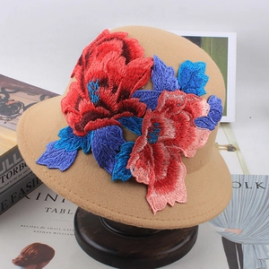 Detailed embroidery on a khaki wool cloche hat with colorful 3D floral needlework