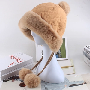 Detail der gesteppten Winter Trappermütze für Damen mit flauschigen Ohrenklappen und Bommeln