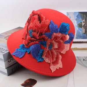 Close-up of red wool felt bucket hat featuring intricate ethnic floral embroidery details