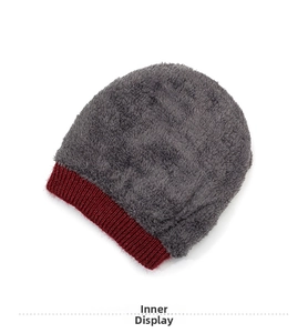 Macro shot of thick grey faux fur lining and red ribbed knit edge for warm winter hat