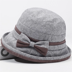Dettaglio della trama in lino e nastro marrone con fiocco su un cappello grigio