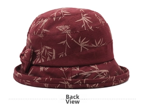 Detail view of the back of a burgundy floral bucket hat with bow and bamboo leaf pattern