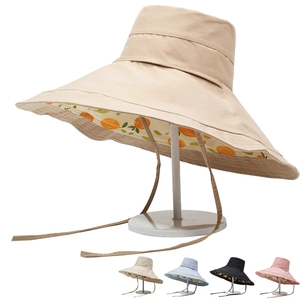Detail of wide brim sun hat featuring orange fruit print lining and adjustable chin strap
