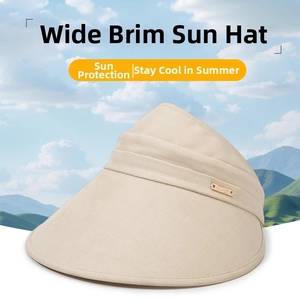 Detail of beige sun hat fabric texture and metallic logo plate with outdoor background