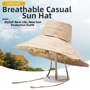 Detail of beige sun hat featuring orange fruit print lining and adjustable wind rope
