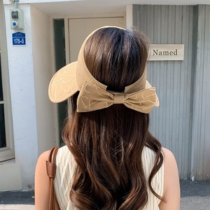 Nahaufnahme des beigen Strick-Visors mit großer Schleife und feinen Stickerei-Details