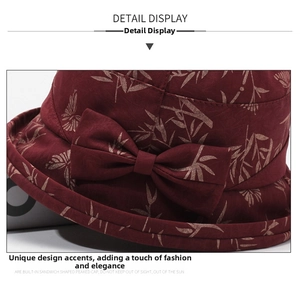 Macro shot of burgundy bucket hat with bamboo leaf print and side bow decoration
