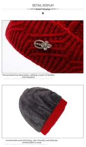 Detail of red knit hat featuring a rhinestone accent and thick grey faux fleece lining