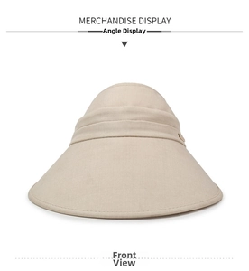 Detailed texture of beige wide-brim sun hat with cotton linen fabric and gold emblem