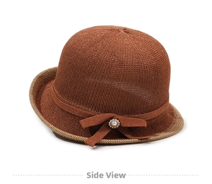 Close-up of brown knit bucket hat with a stylish bow and pearl ornament detail