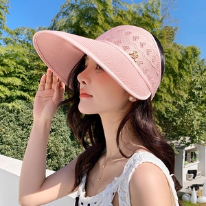 Détail de la visière tricotée rose avec motifs ajourés en cœur et logo R en métal