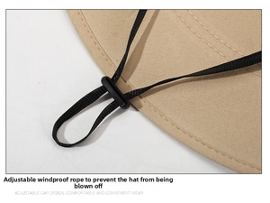 Close-up of adjustable windproof chin strap with toggle on khaki outdoor fishing hat